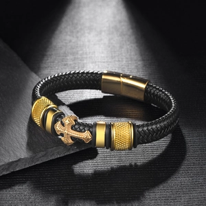Close-up of men's braided leather bracelet with golden engraved cross and magnetic clasp