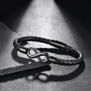 Détail d'un bracelet en cuir tressé pour homme avec symbole infini mat et fermoir magnétique