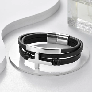 Detalle de una pulsera de cuero multicapa para hombre con cruz y cierre magnético
