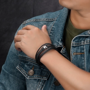 Detail of men's multi-layer braided leather bracelet with silver metal magnetic clasp