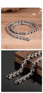 Detailed close-up of retro stainless steel dragon bone chain with ornate dragon head clasp