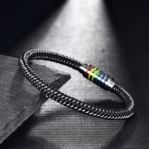 Close-up of woven leather bracelet with rainbow striped magnetic clasp on stone background