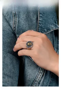 Close-up of men's vintage silver ring with golden lion emblem and cross detail
