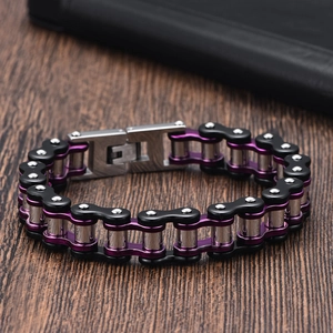 Detail of mechanical bike chain bracelet in purple and black finish on wood background