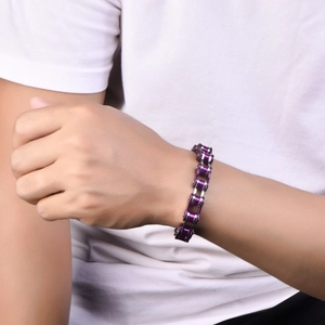 Détail d'un bracelet de moto violet et argenté porté au poignet pour un style hip hop