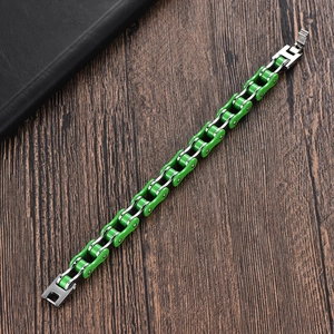 Détail du bracelet chaîne de vélo en acier inoxydable vert et argent sur bois