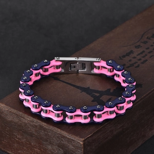 Bracelet chaîne de vélo en acier inoxydable rose et bleu sur une boîte en bois