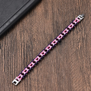 Détail du bracelet chaîne de vélo rose et bleu en acier inoxydable sur bois