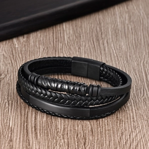 Gros plan d'un bracelet multicouche en cuir noir pour homme avec fermoir métallique