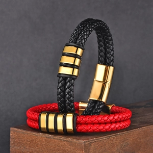 Close-up of woven leather bracelets with golden magnetic buckles on wood base