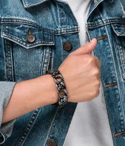 Detail of punk rock style skull bracelet with vintage silver finish on a male model