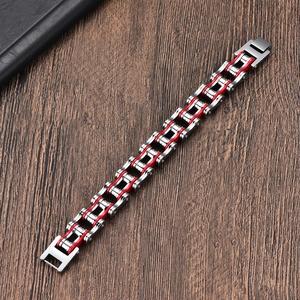 Detail of silver stainless steel motorcycle chain bracelet with vibrant red accents