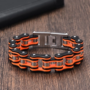 Close-up of orange and black motorcycle chain bracelet with durable metal folding clasp