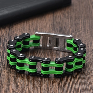 Close-up of green and black stainless steel bicycle chain bracelet on dark wood