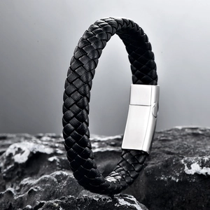Men's black braided leather bracelet with a magnetic silver metal clasp on a stone base