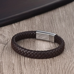Detailed close-up of dark brown braided leather bracelet with silver polished metal buckle
