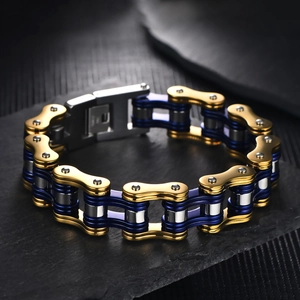 Detail of multi-color gold blue silver bike chain bracelet on black rock background