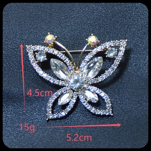 Détail d'une broche papillon en argent sertie de cristaux sur fond de cuir noir texturé