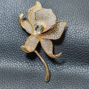 Exquisite gold floral brooch with white rhinestones and a large teardrop crystal