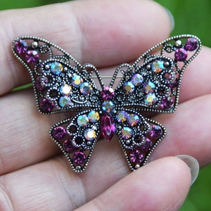 Elegante spilla a farfalla vintage con strass viola e ali traforate intricate