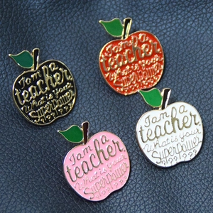 Set of four apple-shaped enamel teacher pins in black, red, white, and pink finishes