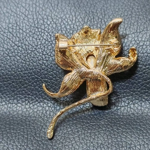 Back view of elegant lily flower brooch in gold plated alloy with secure safety pin
