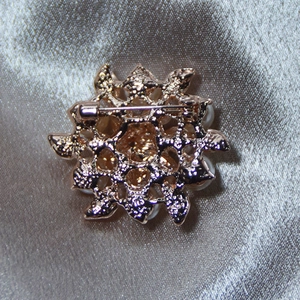 Reverse view of gold-tone pearl flower brooch showing the secure metal pin fastening