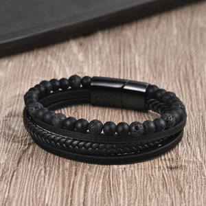 Detail of men's multi-layer black braided leather and volcanic rock bead bracelet