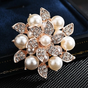 Elegant floral alloy brooch with white pearls and sparkling zircon on a velvet base