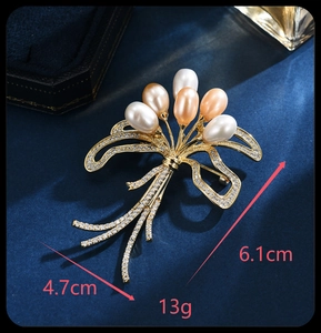 Detail view of pearl ribbon brooch with dimensions 6.1cm by 4.7cm on blue velvet