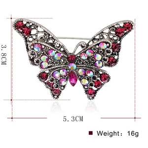 Spilla farfalla vintage con strass magenta scuro e lavorazione in lega traforata
