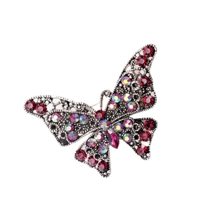 Spilla a farfalla vintage con strass rossi e lega d'argento su sfondo bianco neutro