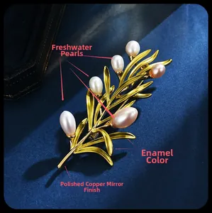 Close-up of golden pine branch brooch with freshwater pearls and enamel inlay