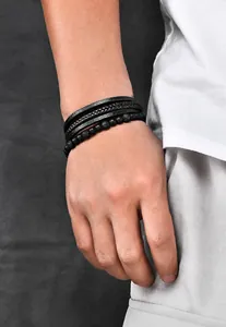 Detailed close-up of multilayered black braided leather and tiger eye stone men's bracelet