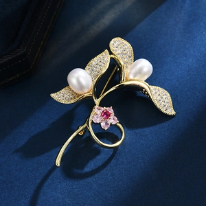 Elegant bean sprout brooch with freshwater pearls and zircon leaves on blue velvet background