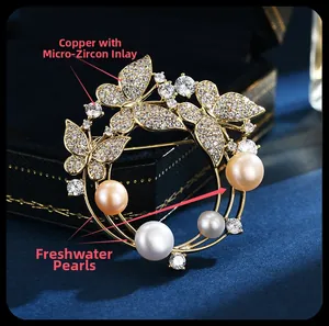 Detalle macro de broche de corona de mariposa en cobre con circonitas y perlas