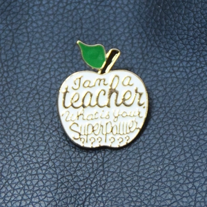 Detail of apple teacher brooch with I am a teacher what is your superpower text