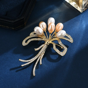 Elegant floral freshwater pearl ribbon brooch with gold finish and sparkling crystals