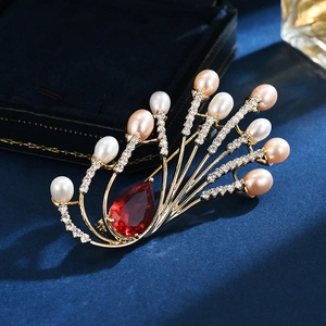 Elegant bow brooch featuring natural pearls, red pear gemstone and sparkling zircon accents