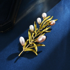 Elegant golden olive branch brooch with six natural pearls on a dark blue textured background
