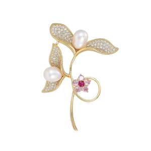 Golden branch brooch with freshwater pearls and pink gemstone flower on white background