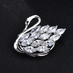 Détail macro d'une broche cygne argentée sertie de zircons cubiques de taille marquise