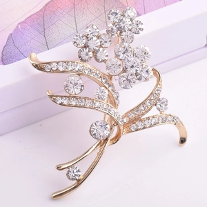 Dettaglio di elegante spilla a fiore dorato con strass scintillanti e decorazioni di foglie
