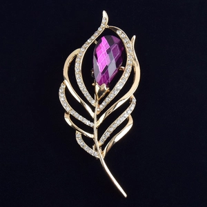 Détail de la broche plume dorée avec cristal violet en goutte et accents de zircons brillants