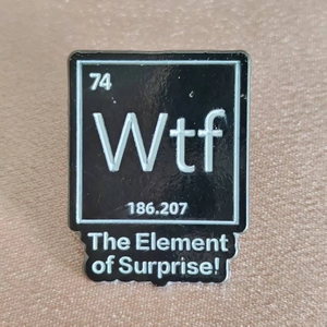 Funny chemistry enamel pin featuring Wtf element of surprise on a metallic background