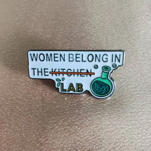 Broche créative en émail avec slogan Women Belong in the Lab sur fond texturé