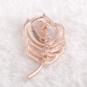 Vue arrière d'une broche plume en or rose avec épingle de sûreté et texture en alliage