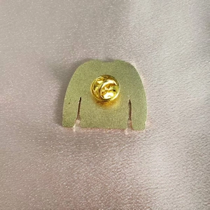 Broche dorée en métal en forme de pull avec fermoir papillon sur satin rose