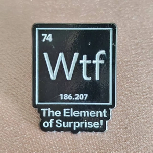 Detailed macro view of an enamel chemistry pin on silk fabric with Wtf element design