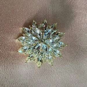 Vue détaillée d'une broche flocon de neige en cristal de luxe sur un tissu en satin rose doré